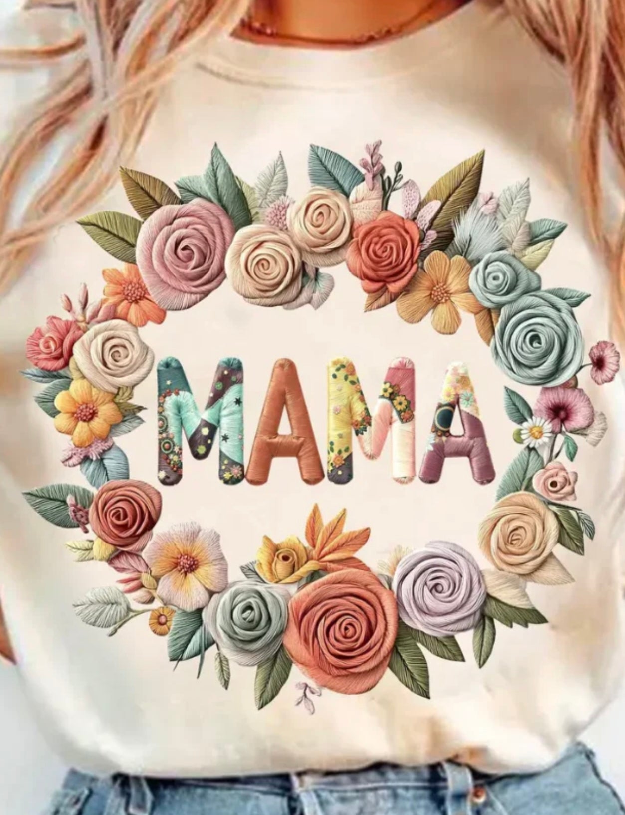 White sweatshirt with floral design spelling 'MAMA' on a plain background