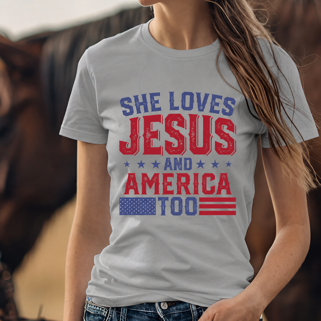 Person wearing a sport gray colored t-shirt with 'She Loves Jesus and America Too' text and American flag design.