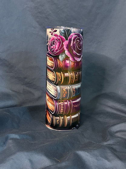 Tumbler with book and rose design on a dark fabric background