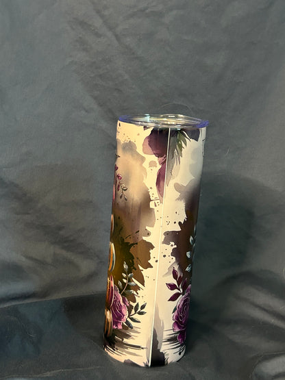 Tumbler with book design on a gray surface.