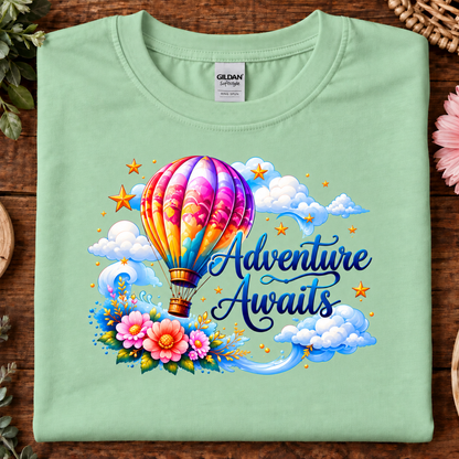 Mint green colored t-shirt with a hot air balloon flying in the clouds with the text Adventure Awaits