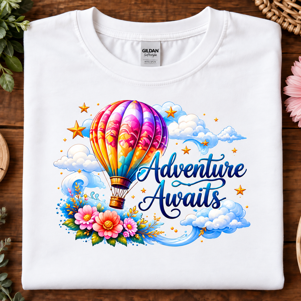 White colored t-shirt with a hot air balloon flying in the clouds with the text Adventure Awaits