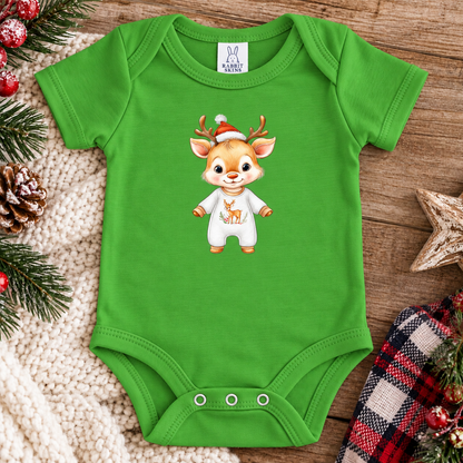 A apple green baby bodysuit with a cartoon deer graphic wearing a Santa hat and white outfit, laid flat on a wooden surface with holiday decorations around it. The neck label shows the brand 'K&H Baby'.