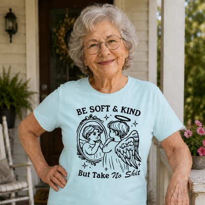 Woman wearing a light blue t-shirt with an angel graphic and text on a porch.
