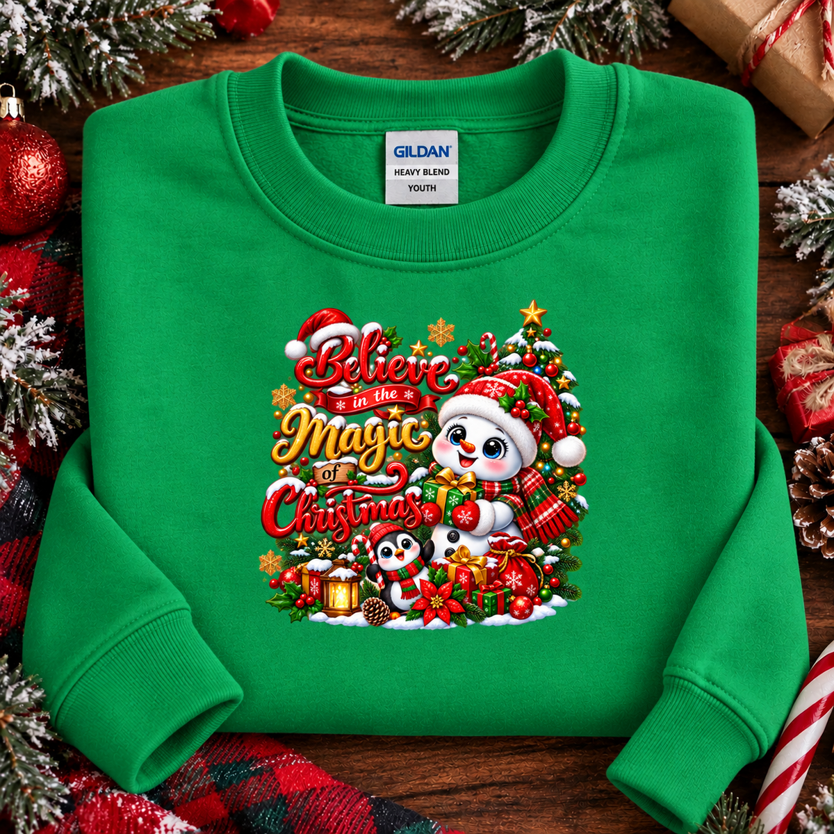 A bright green crewneck sweatshirt with a colorful Christmas graphic on the chest, laid flat on a rustic wooden surface surrounded by holiday decorations like pine branches, ornaments, and wrapped gifts. The Gildan brand label is visible inside the collar.
