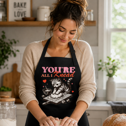 Woman baking bread wearing funny cat apron You’re All I Knead design black apron