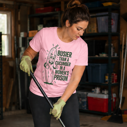 Woman wearing a blossom colored t-shirt with a graphic design saying Busier than a cucumber  humorous text cleaning a garage.