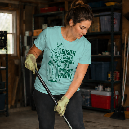 Woman wearing a chalky mint colored t-shirt with a graphic design saying Busier than a cucumber  humorous text cleaning a garage.