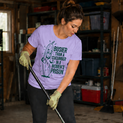 Woman wearing a orchid colored t-shirt with a graphic design saying Busier than a cucumber  humorous text cleaning a garage.