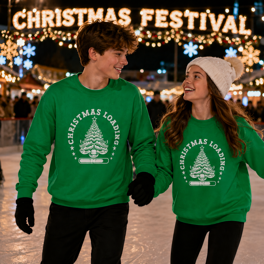 Two people wearing green 'Christmas Loading' sweatshirts at a Christmas festival.
