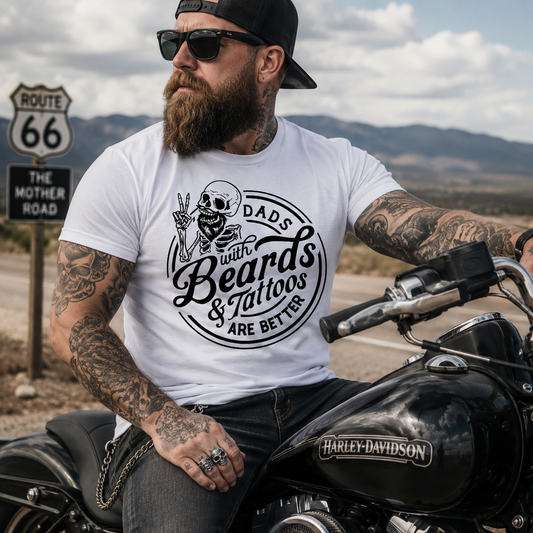 Man with tattoos and a beard sitting on a motorcycle wearing a t-shirt with a graphic design.