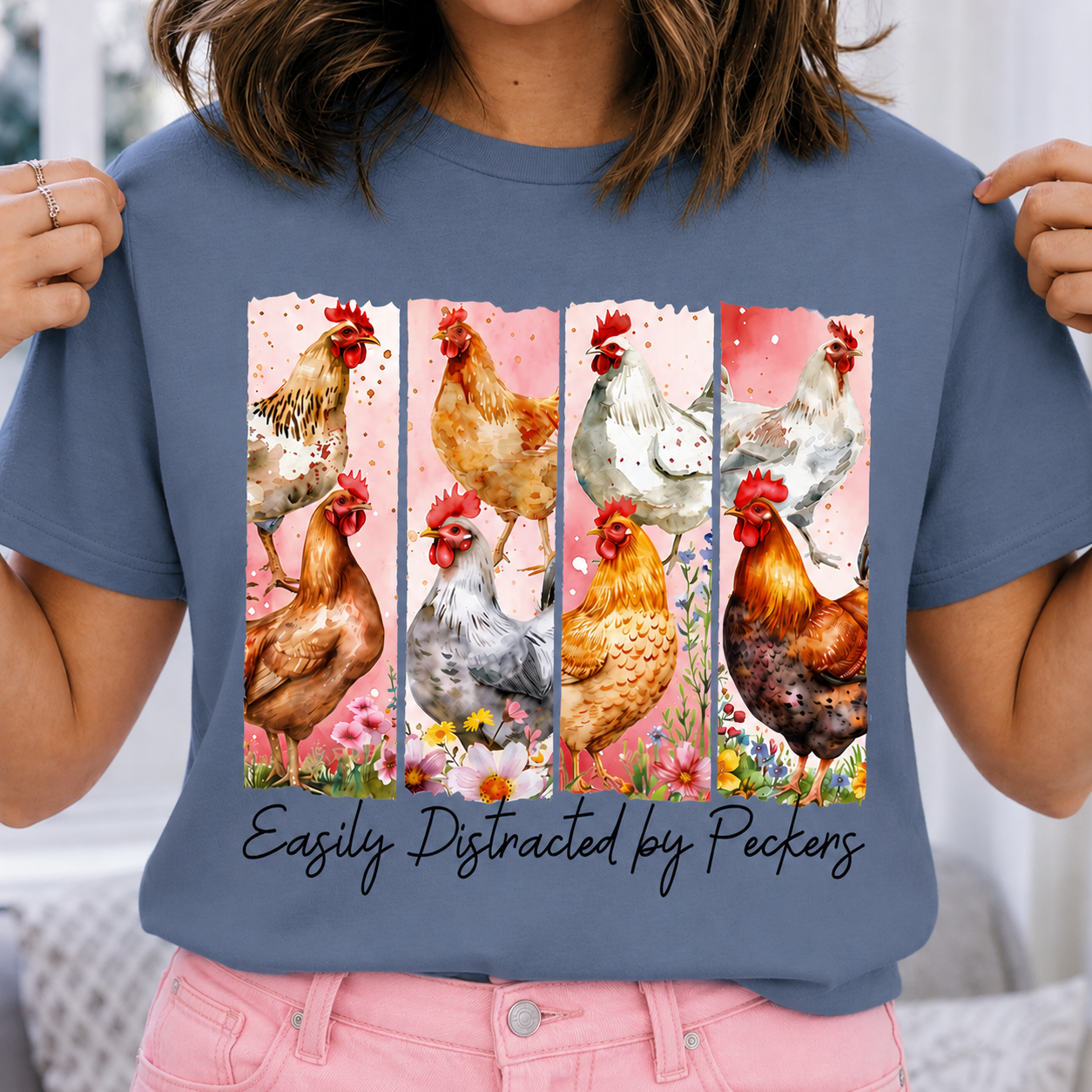 Blue Jean colored t-shirt with chicken design and text 'Easily Distracted by Peckers' held by a person.