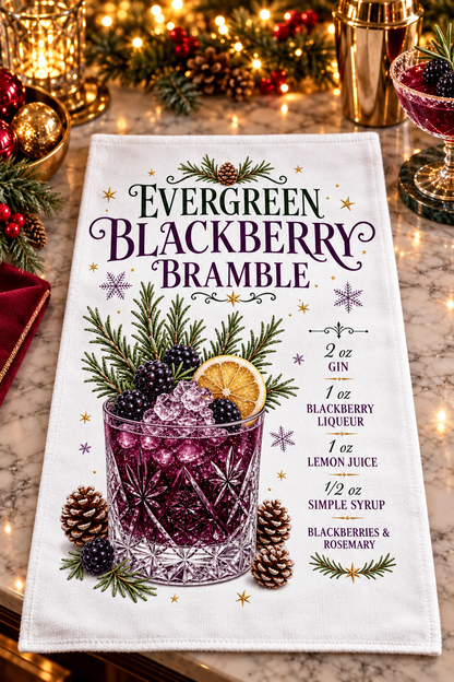 A white kitchen towel printed with a festive Christmas-themed cocktail recipe for 'Evergreen Blackberry Bramble'. The towel features a graphic design of a glass filled with purple-blackberry drink, garnished with berries, rosemary, and a lemon slice, surrounded by pinecones and evergreen branches.