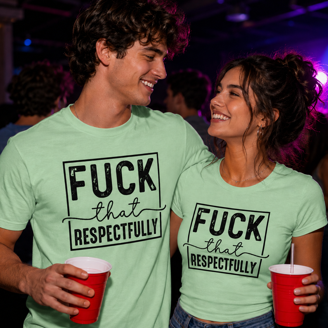 Two people wearing matching green t-shirts with text at a party.