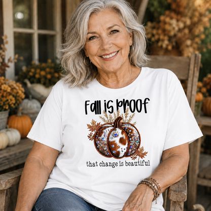 Woman wearing a white t-shirt  with the phrase “Fall Is Proof That Change Is Beautiful” in faux-embroidery style.