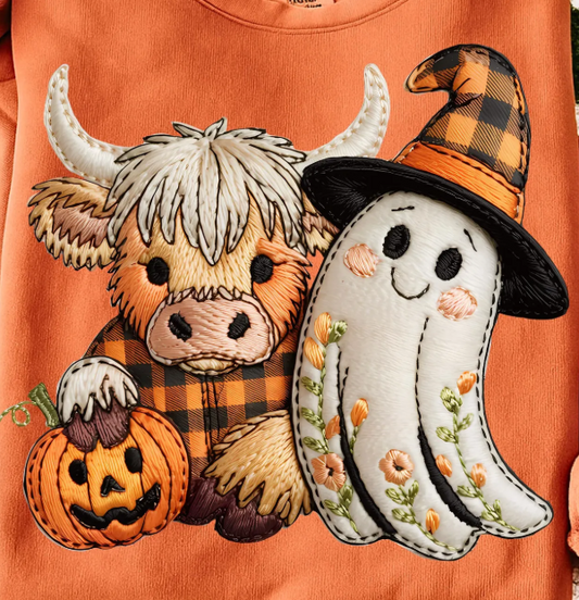 Embroidered patch of a cow with a pumpkin and a ghost wearing a witch hat on an orange background