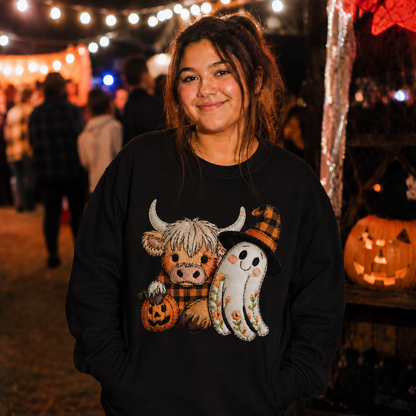 Person wearing a black sweater with a Halloween-themed design.