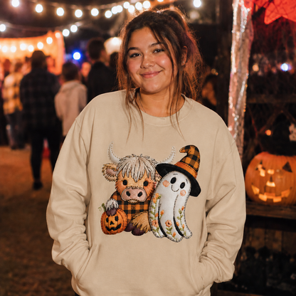 Person wearing a sand colored sweatshirt with Halloween-themed design at an outdoor event.