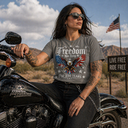 Woman sitting on a motorcycle wearing a graphic t-shirt with an eagle design 250 years and text.