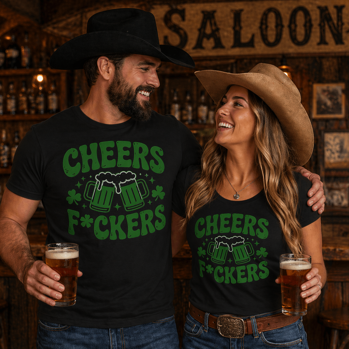 Two people in a saloon wearing matching 'Cheers F*ckers' shirts with drinks.