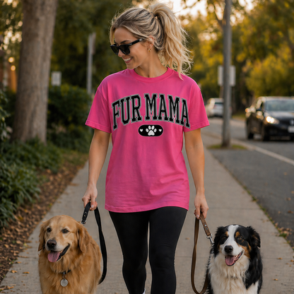 Woman walking two dogs on a sidewalk wearing a pink 'FUR MAMA' t-shirt.