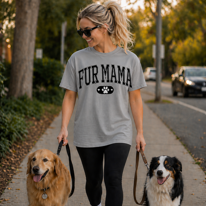 Woman walking two dogs on a sidewalk wearing a  sport gray colored T-shirt with 'FUR MAMA' text.