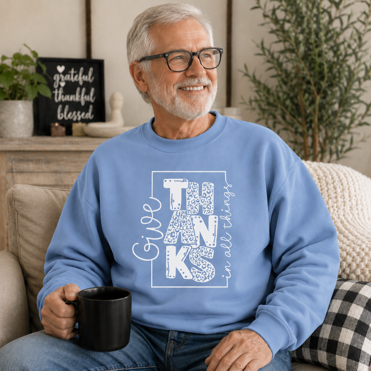 Man wearing a carolina blue colored sweatshirt with text “Give Thanks in All Things” soft, comfy, and perfect for Thanksgiving or everyday fall wear