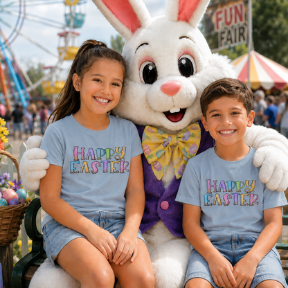Two children wearing light blue t-shirts with the saying 'Happy Easter' sitting with a large Easter Bunny at a funfair.