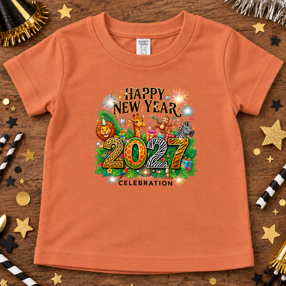 An sunset orange short-sleeve kids' t-shirt with a colorful 'Happy New Year 2027 Celebration' graphic featuring cartoon animals and fireworks, displayed on a wooden surface with party decorations.