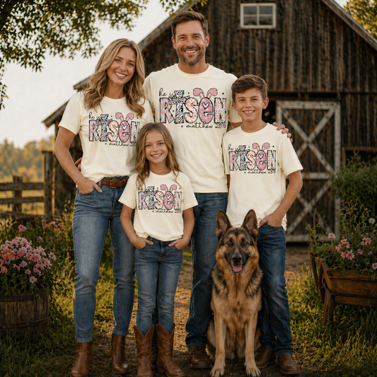 Family of four wearing a He is risen graphic t-shirt with a dog standing in front of a wooden barn.