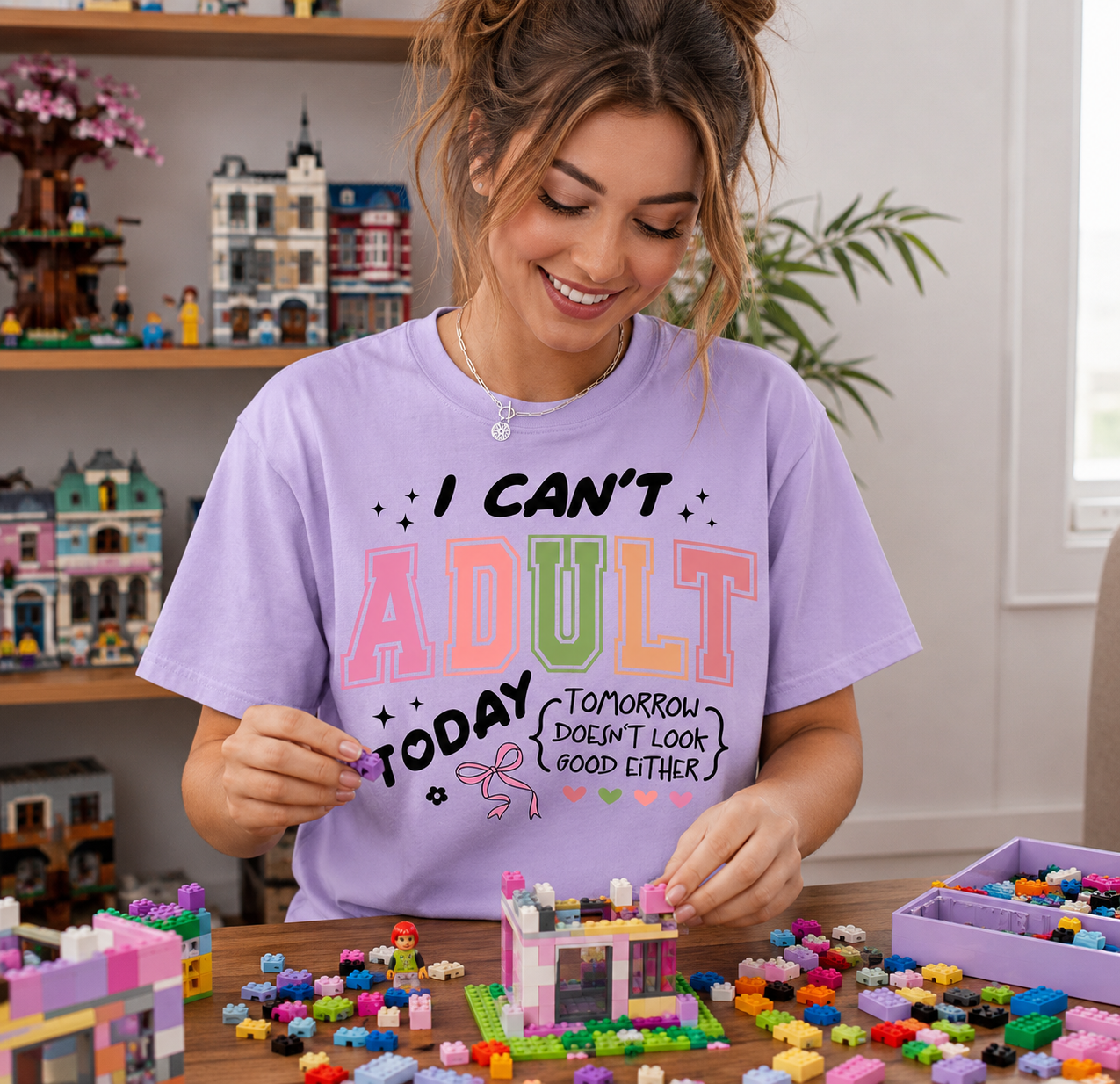 Woman wearing a purple t-shirt with colorful text, playing with building blocks.