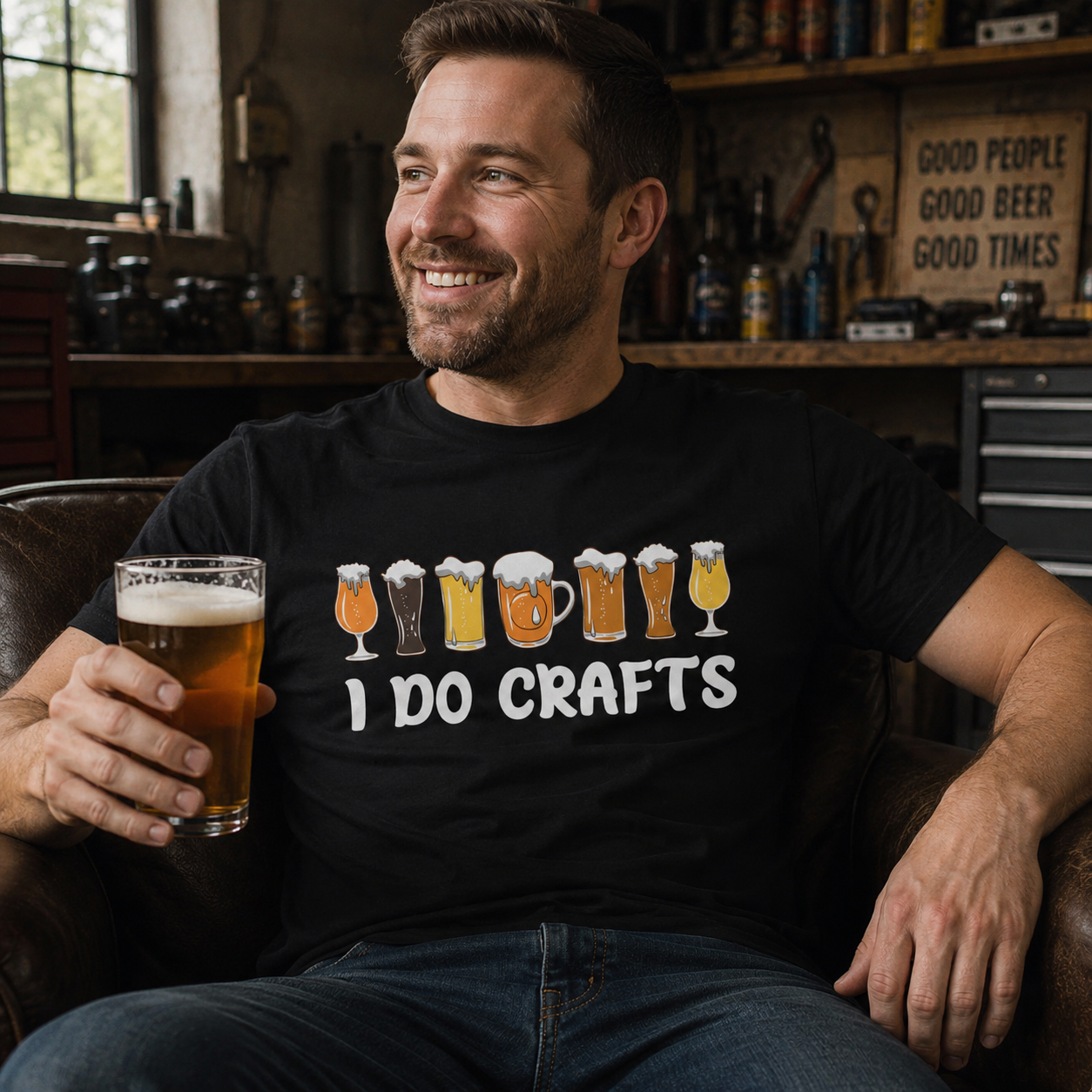 Man sitting in a chair holding a glass of beer, wearing a 'I Do Crafts' black colored t-shirt.
