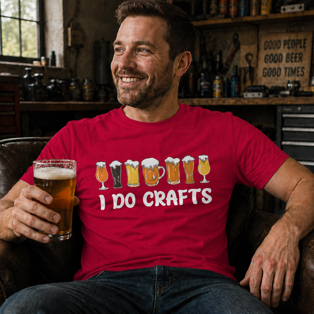 Man sitting in a chair holding a glass of beer, wearing a 'I Do Crafts' heather red colored t-shirt.