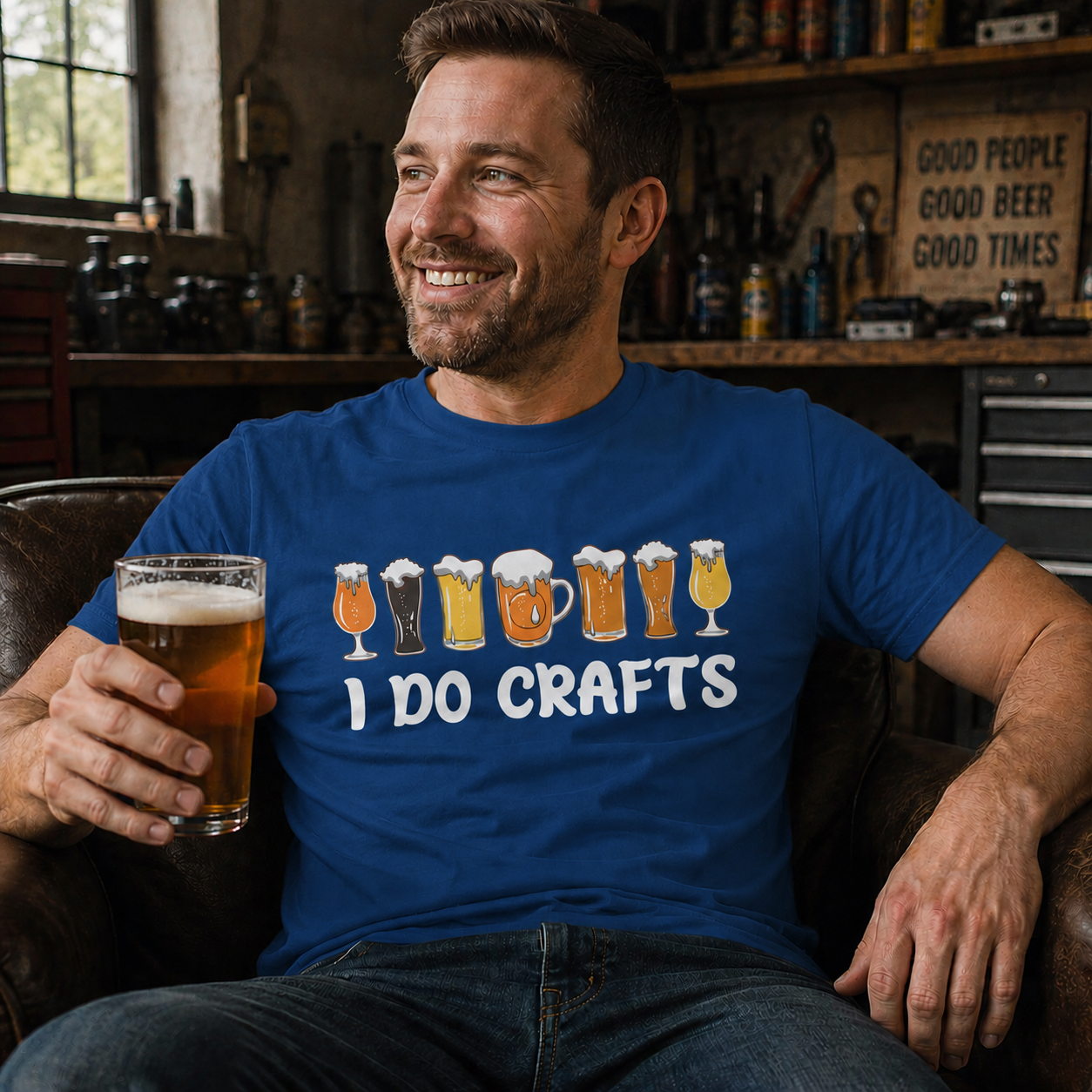 Man sitting in a chair holding a glass of beer, wearing a 'I Do Crafts' royal blue colored t-shirt.