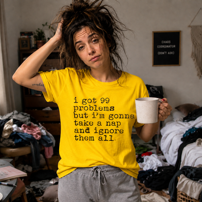 Person wearing a daisy colored t-shirt with I got 99 problems but I'm gonna take a nap and ignore it all