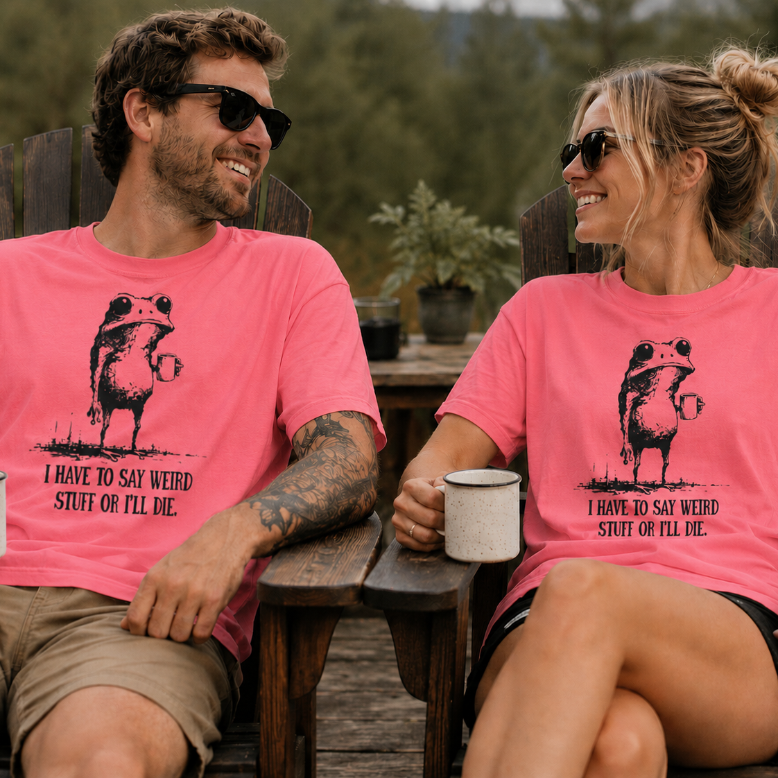 Two people sitting outdoors wearing matching coral silk t-shirts with a graphic of a frog with humorous text