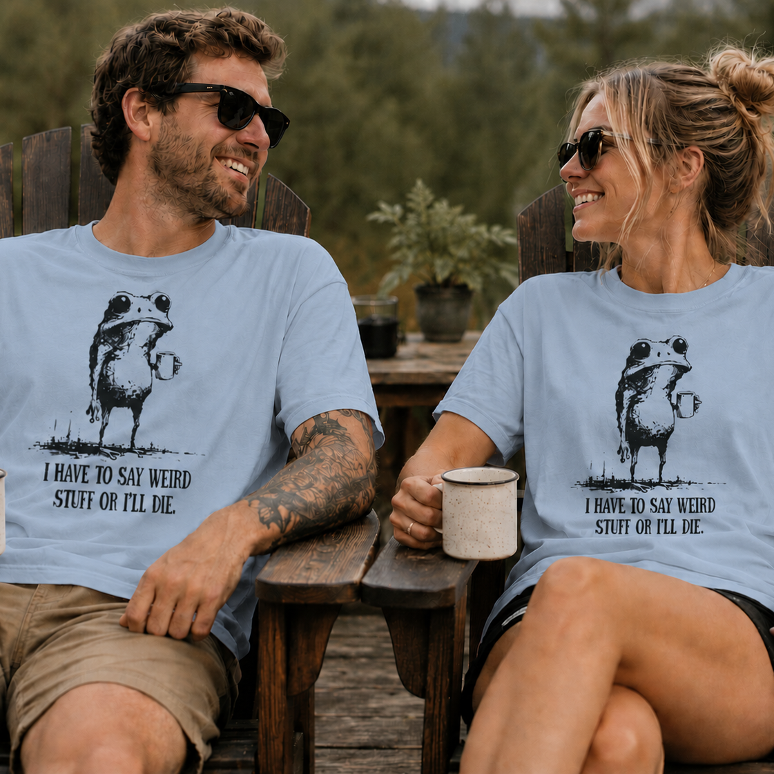 Two people sitting outdoors wearing matching light blue t-shirts with a graphic of a frog with humorous text