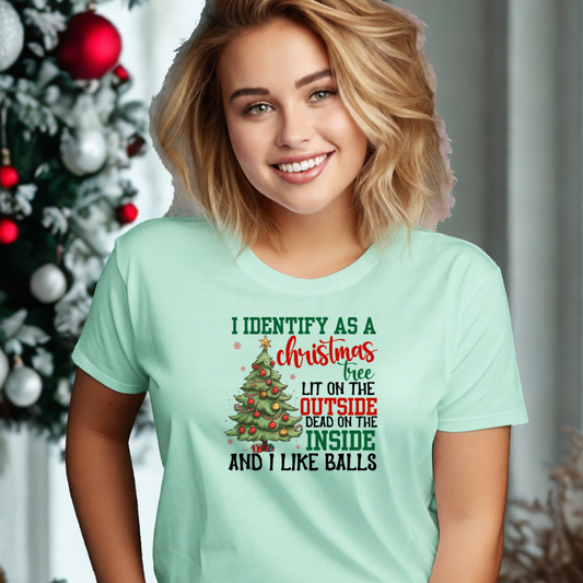 A woman wearing a mint green t-shirt with a Christmas tree graphic with the words I identify as a Christmas tree lit on the outside dead on the inside and I like balls
