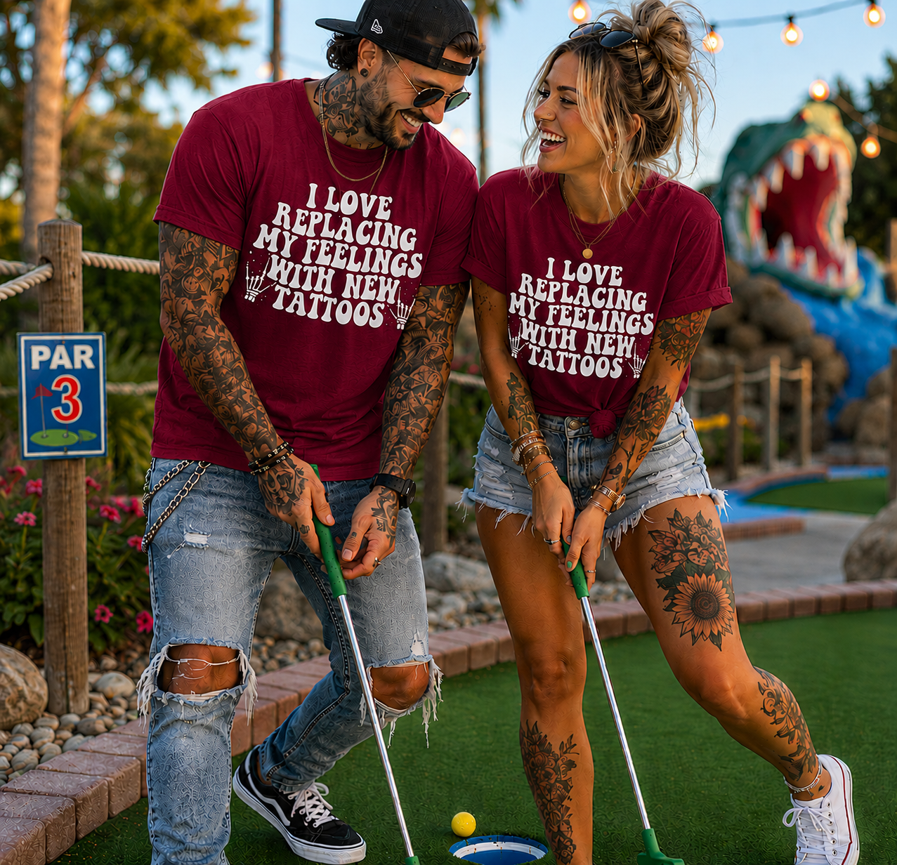 People wearing a cardinal red colored  t-shirt with I love replacing my feelings with new tattoos white text design.