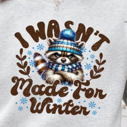 Graphic sweatshirt featuring a grumpy raccoon with a funny winter theme, perfect for staying cozy in cold weather.