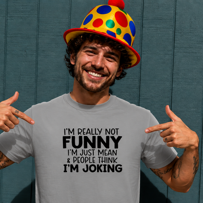 Man wearing a gray t-shirt with humorous text and a colorful clown hat against a blue background