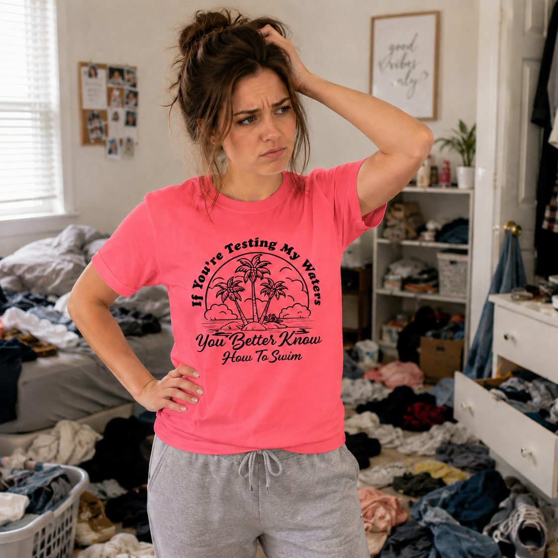 Woman in a pink t-shirt with text in a messy room