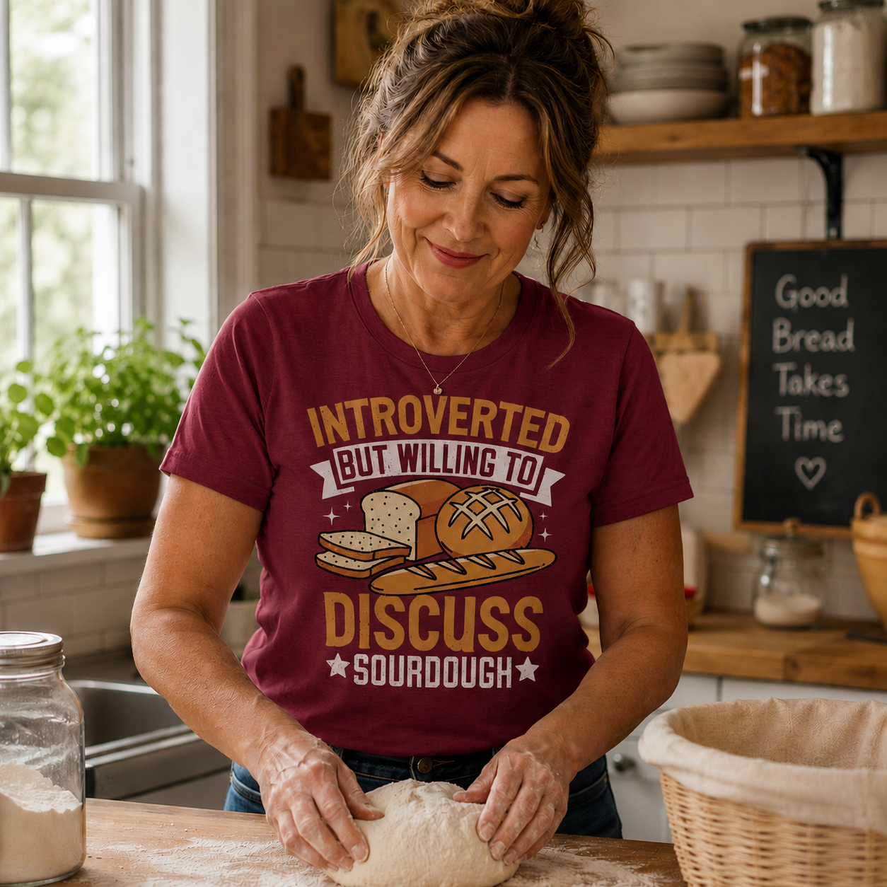 Woman in a kitchen wearing a cardinal red colored t-shirt about sourdough bread, kneading dough.
