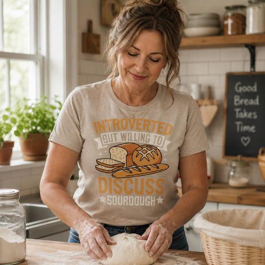 Woman in a kitchen wearing a sand colored t-shirt about sourdough bread, kneading dough.