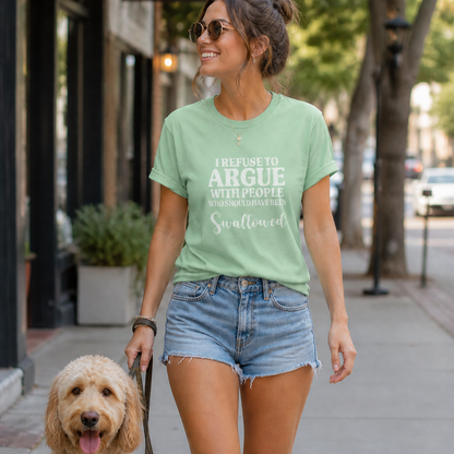 Woman walking a dog on a city street wearing a green t-shirt with text.