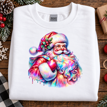 A folded white Gildan t-shirt with a colorful, rainbow-iridescent Santa Claus graphic, displayed on a rustic wooden table with Christmas decorations.
