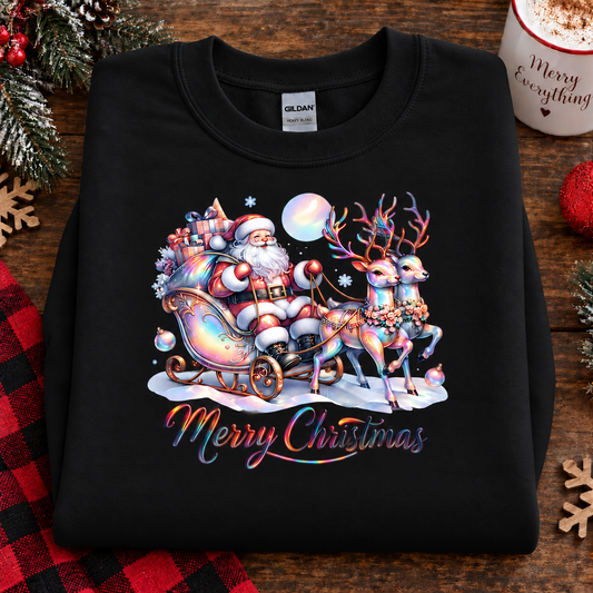 A black Gildan sweatshirt featuring a colorful Christmas graphic of Santa Claus in a sleigh pulled by reindeer under a full moon, with 'Merry Christmas' written below, displayed on a rustic wooden background with holiday decorations.