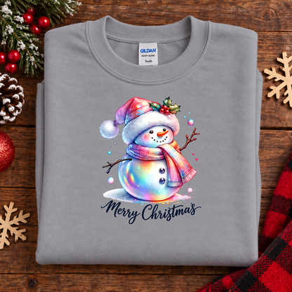 A folded sport gray Gildan Youth crewneck sweatshirt with a colorful Christmas snowman graphic and 'Merry Christmas' text, displayed on a rustic wooden background with holiday decorations.