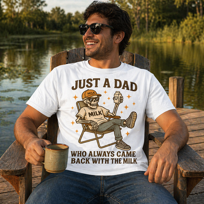 Man wearing a white t-shirt with a graphic and text, sitting by a lake.