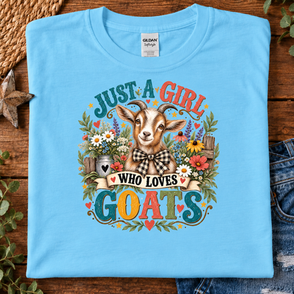 A folded sky blue Gildan brand t-shirt with a colorful graphic of a goat and the text 'JUST A GIRL WHO LOVES GOATS' in a floral, rustic design.